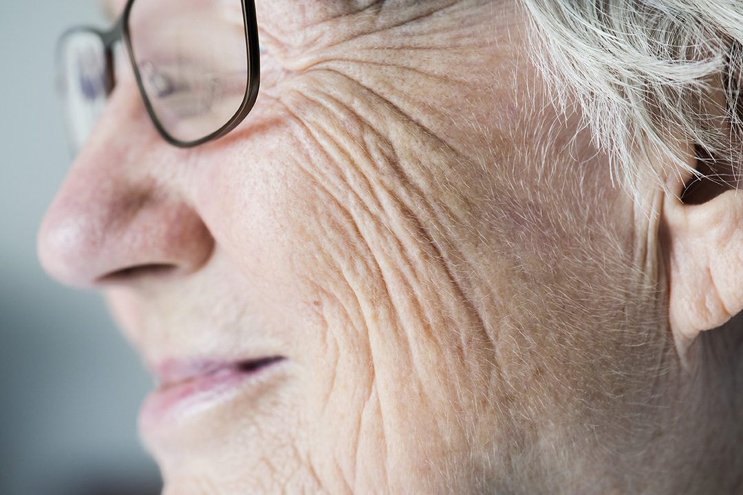 Side closeup portrait of white elderly woman