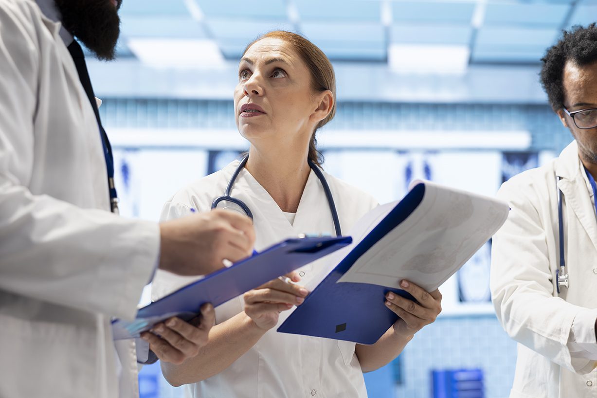 Team of doctors comparing test results and healthcare records in office