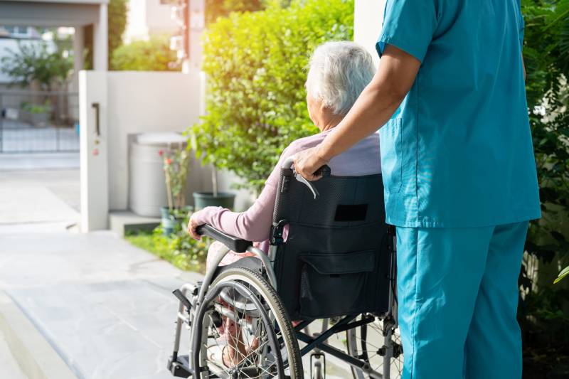 caring-assistant-pushing-senior-woman-in-wheelchai-2026-09-23-19-14-56-utc (1)